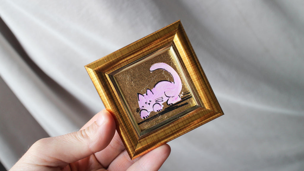 Hand-painted miniature pink cat oil painting with gold leaf background in a gold frame